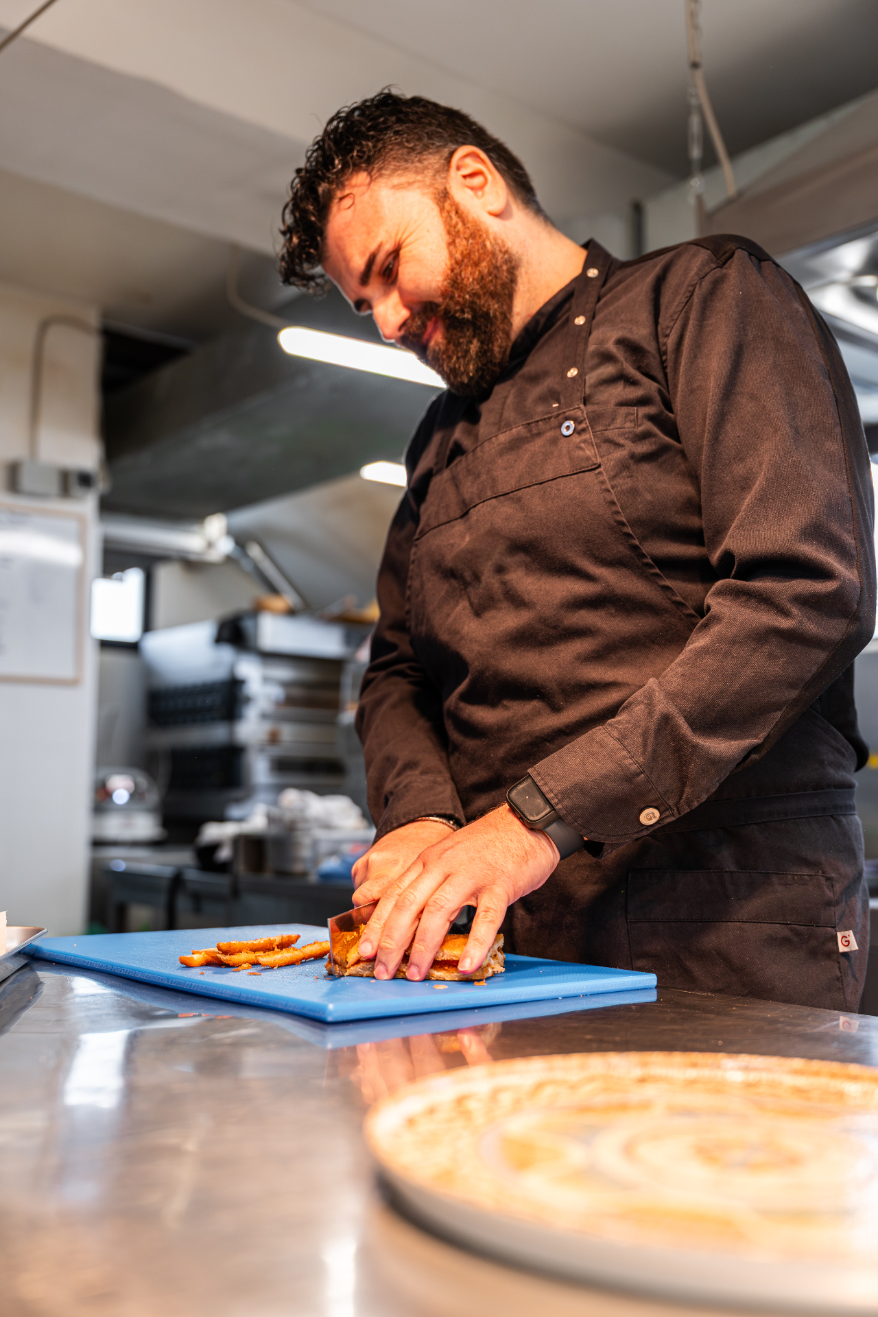 Chef taglia ingredienti in cucina professionale — food photography Bolzano
